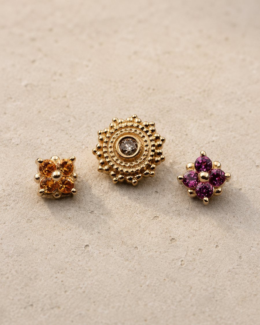 Three BVLA gold ends set down on stone: a citrine cluster, a beaded mandala and a rhodolite cluster